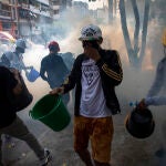 28 February 2021, Myanmar, Yangon: Protesters wearing helmets try to extinguish smoking tear gas canisters during clashes at a protest against the military coup and detention of civilian leaders in Myanmar. At least 18 people were killed and more than 30 wounded in Myanmar as police and military cracked down on anti-coup protesters in the country on Sunday, the UN Human Rights Office said. Photo: Thuya Zaw/ZUMA Wire/dpa28/02/2021 ONLY FOR USE IN SPAIN