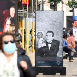 Varias personas pasean por calle Larios, donde ha sido inaugurada la exposición de fotografías con motivo de la celebración en Málaga de los Goya
