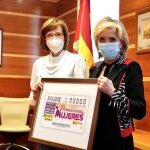 La consejera de Sanidad, Verónica Casado, recibe de la presidenta de la Once en Castilla y León, Rosa María Rubio Lázaro, un cupón conmemorativo con motivo del 8M