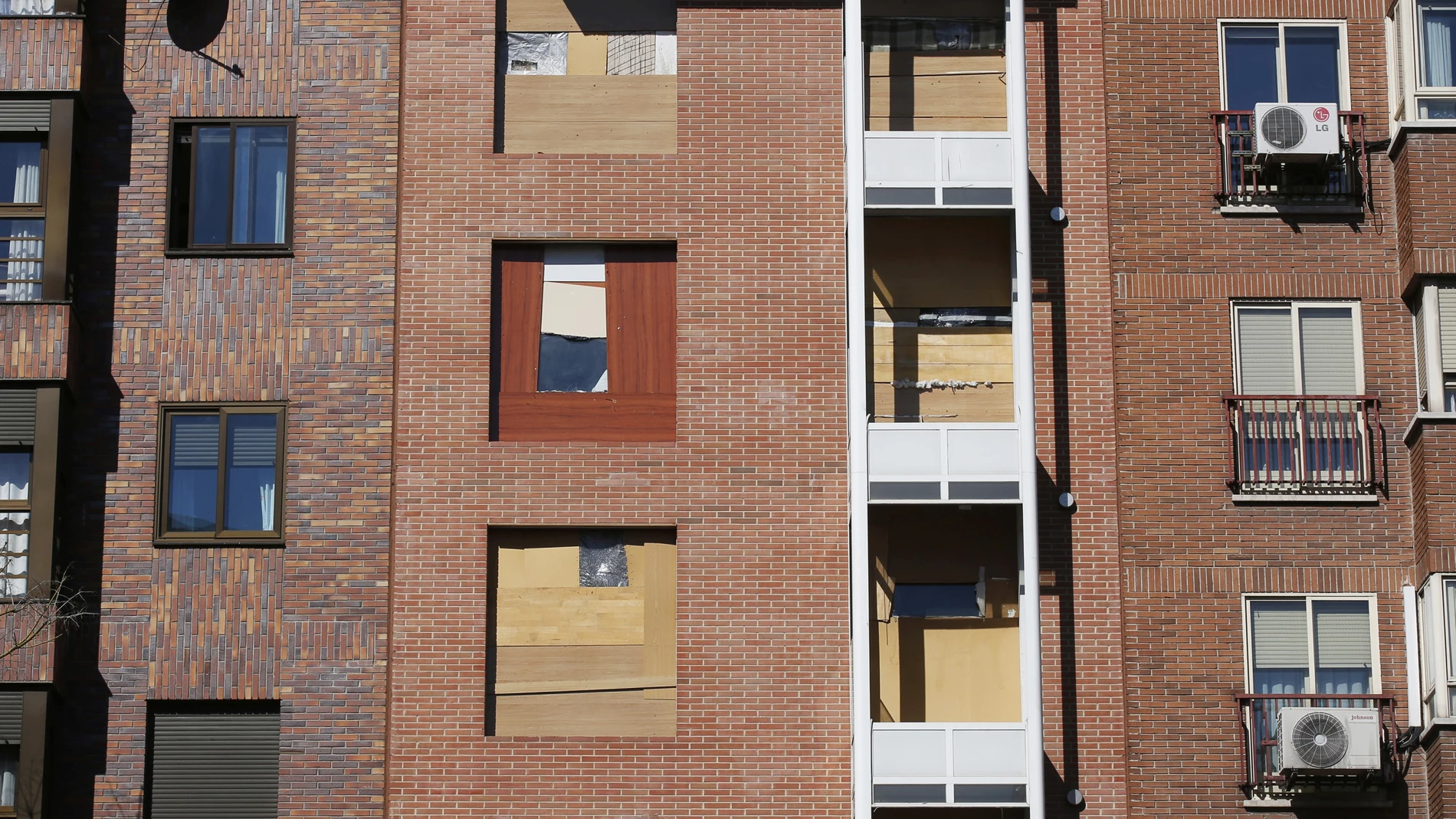 Un edificio ocupado ilegalmente con tablas de madera en las ventanas
