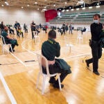 Varios agentes de la Guardia Civil de Cartagena distribuidos en el pabellón deportivo del Polígono Cabezo Beata de Cartagena esperan para que les administren la vacuna contra el Covid-19