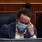 El vicepresidente segundo del Gobierno, Pablo Iglesias, se toca la cabeza durante una sesión de control al Gobierno en el Congreso de los Diputados