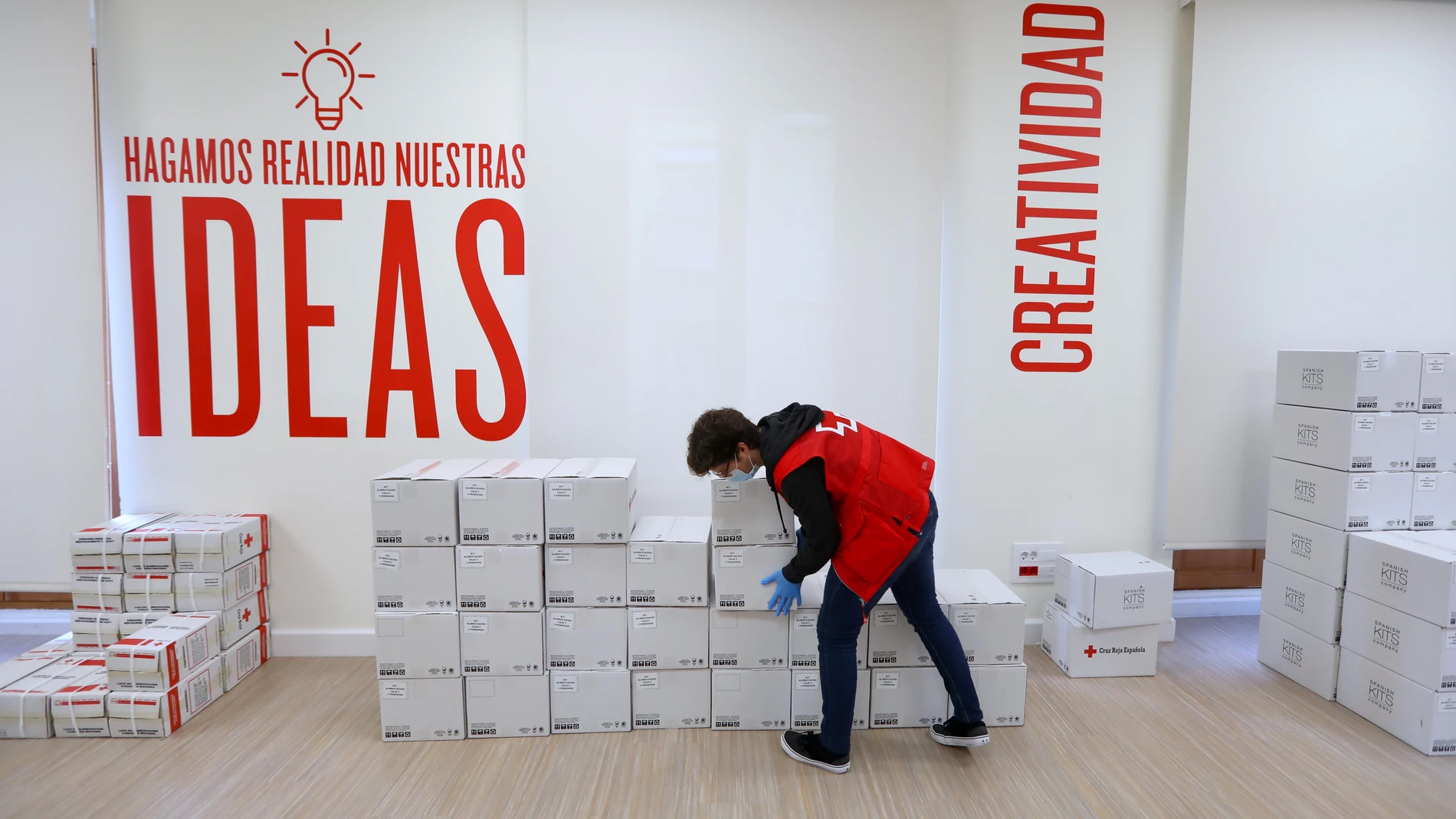 Un voluntario de la Cruz Roja en la Unidad de Respuesta Social, llevando cajas de alimentos y bienes básicos a los hogares sin medios