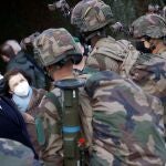 El presidente francés Emmanuel Macron, flanqueado por la ministra de Defensa francesa, Florence Parly, habla con soldados durante una visita a Ferme du Cuin, el centro de entrenamiento del 4o Regimiento de la Legión Extranjera, en Saint-Gauderic