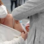 Un sanitario vacuna a una mujer en el Instituto Ferial de Vigo (Ifevi), en Pontevedra, Galicia