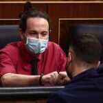 El vicepresidente segundo del Gobierno, Pablo Iglesias saluda con el puño al portavoz de ERC en el Congreso, Gabriel Rufián, durante una sesión de Control al Gobierno en el Congreso de los Diputados