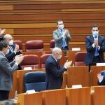 El presidente de la Junta de Castilla y León, Alfonso Fernández Mañueco (d), recibe los aplausos de sus compañeros de partido durante el debate de la primera moción de censura de la historia autonómica, presentada por el PSOE para desbancar de la Presidencia a Alfonso Fernández Mañueco (PP) y de la Vicepresidencia a Francisco Igea (Cs), este lunes en las Cortes de Castilla y León.