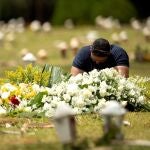 AME4755. BRASILIA (BRASIL), 23/03/2021.- Un hombre visita una tumba en el cementerio Campo de Esperanza, hoy, en Brasilia (Brasil). Brasil bordea los 300.000 muertos por covid-19, mientras persiste el riesgo de desabastecimiento de medicamentos esenciales para los enfermos con cuadros más graves ante el creciente número de hospitalizaciones. EFE/ Joédson Alves.