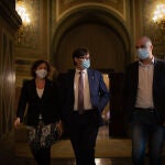 El candidato del PSC a la Presidencia de la Generalitat, Salvador Illa (centro), acompañado de los diputados socialistas Alicia Romero y Raúl Moreno, en los pasillos del Parlament