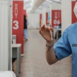 Una profesional sanitaria sostiene una jeringuilla con la vacuna de AstraZeneca, en el Hospital la Fe, en Valencia