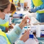 Personal sanitario durante la vacunación a docentes, cuerpos de seguridad del Estado y bomberos, en el recinto ferial de Fermasa, Armilla, en Granada.