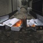 FILE - In this June 24, 2020 file photo, crematorium workers burn the coffins that contained the remains of people who died from the coronavirus after their cremation at the San Nicolas Tolentino cemetery in the Iztapalapa neighborhood of Mexico City. As Mexico approaches 200,000 in officially test-confirmed deaths from COVID-19, the real death toll is probably higher due to the countryâ€™s extremely low rate of testing. (AP Photo/Marco Ugarte, File)