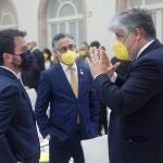 El candidato de ERC a la presidencia de la Generalitat, Pere Aragonès, conversa con los diputados de JxCat, Albert Batet (d) y Ramón Tremosa (c), a su llegada al Auditori del Parlament de Catalunya donde este viernes se somete al debate de investidura, con una primera votación en la que necesita la mayoría absoluta de los votos, que previsiblemente no alcanzará porque JxCat ya ha anunciado su abstención. EFE/Quique García POOL