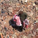 Un hombre camina sobre los escombros del edificio de apartamentos derrumbado en El Cairo