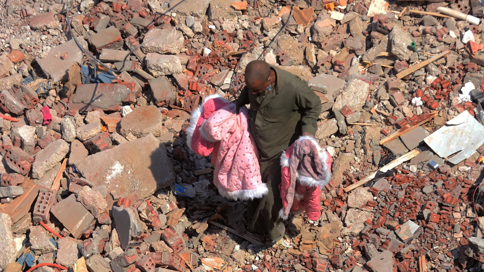 Un hombre camina sobre los escombros del edificio de apartamentos derrumbado en El Cairo