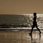 Una mujer camina por la orilla de la playa de Maspalomas, en el sur de Gran Canaria.