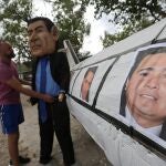 Fotografía que muestra a un joven mientras sostiene un monigote con la imagen de Juan Antonio "Tony" Hernández, en Germania (Honduras). Juan Antonio "Tony" Hernández, hermano del presidente hondureño, Juan Orlando Hernández, condenado a cadena perpetua por narcotráfico