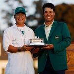 Hideki Matsuyama y su 'caddie' posan con el trofeo de ganadores del Masters de Augusta.