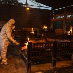 Familiares y trabajadores municipales con equipos de protección personal realizan los últimos ritos a las víctimas de la Covid-19, durante su funeral en un crematorio en Vasai, a las afueras de Bombai, IndiaE/EP /DIVYAKANT SOLANKI