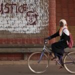 Una niña pasa por delante de un grafiti en la que se puede leer "Justicia" en Ouagadougou, la capital de Burkina FAso