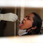 New Delhi (India), 15/04/2021.- A woman has her swab sample collected to be tested for COVID-19 in New Delhi, India, 15 April 2021. A weekend curfew was announced on 15 April in Delhi as India recorded its highest daily spike of COVID-19 cases on 14 April with around 200,000 new infections in 24 hours. (Nueva Delhi) EFE/EPA/RAJAT GUPTA