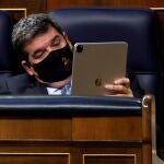 El ministro de Inclusión, Seguridad Social y Migraciones, José Luis Escrivá, revisa su tablet durante uno de los plenos del Congreso