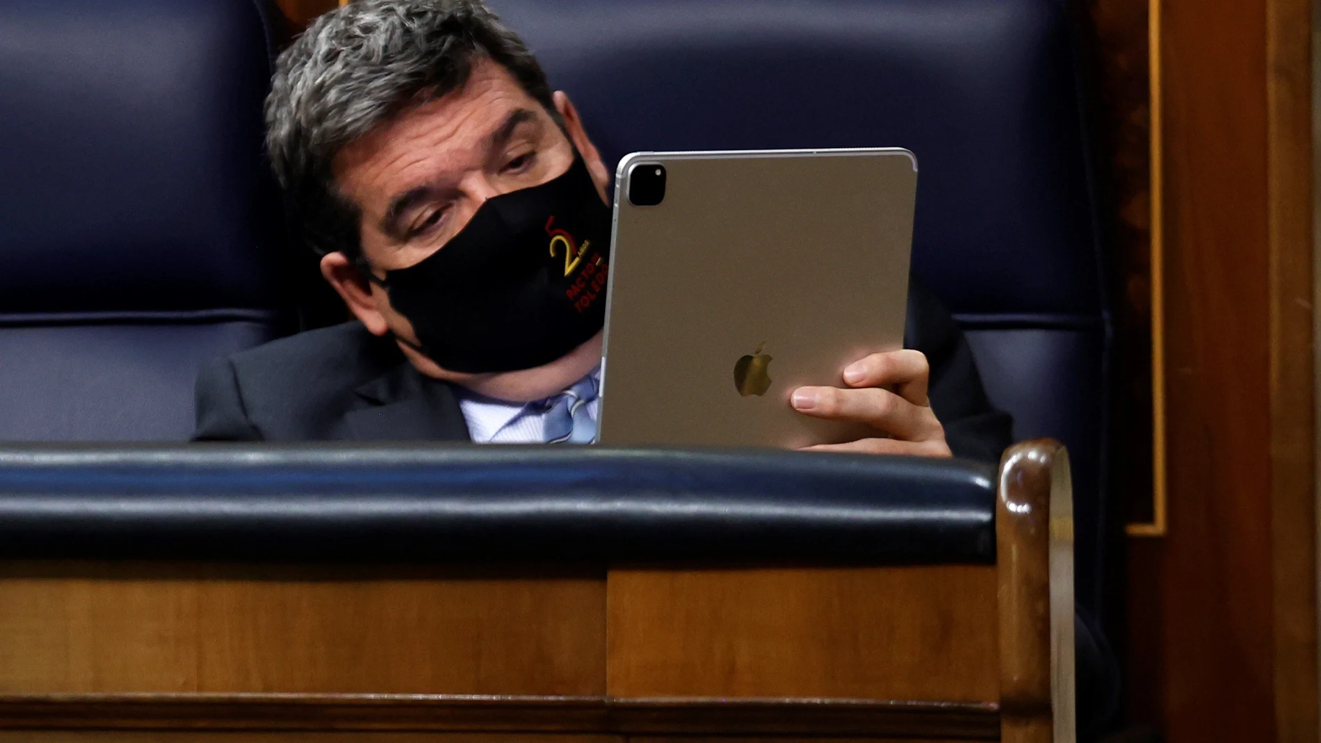 El ministro de Inclusión, Seguridad Social y Migraciones, José Luis Escrivá, revisa su tablet durante uno de los plenos del Congreso