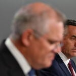 El ministro de Asuntos de Veteranos, Darren Chester (d), observa cómo el primer ministro australiano Scott Morrison (izq.) habla a los medios de comunicación durante una conferencia de prensa en Sydney, Australia