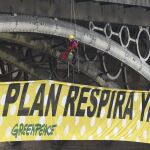 Activistas de Greenpeace despliegan una pancarta como protesta contra el cambio climático en el puente de Triana