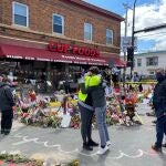 Dos personas se abrazan frente a la esquina en la que murió asfixiado George Floyd, durante una concentración en su honor en Mineápolis