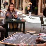 Una hostelera renueva la carta de su establecimiento en una pizarra. EFE/ Raúl Caro.