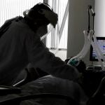 Una empleada de la salud atiende a un paciente en una unidad de cuidados intensivos para enfermos de Covid-19