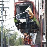Bomberos y operarios del área de emergencias trabajan para retirar uno de los vagones que colapsaron en la noche de este lunes en Ciudad de México