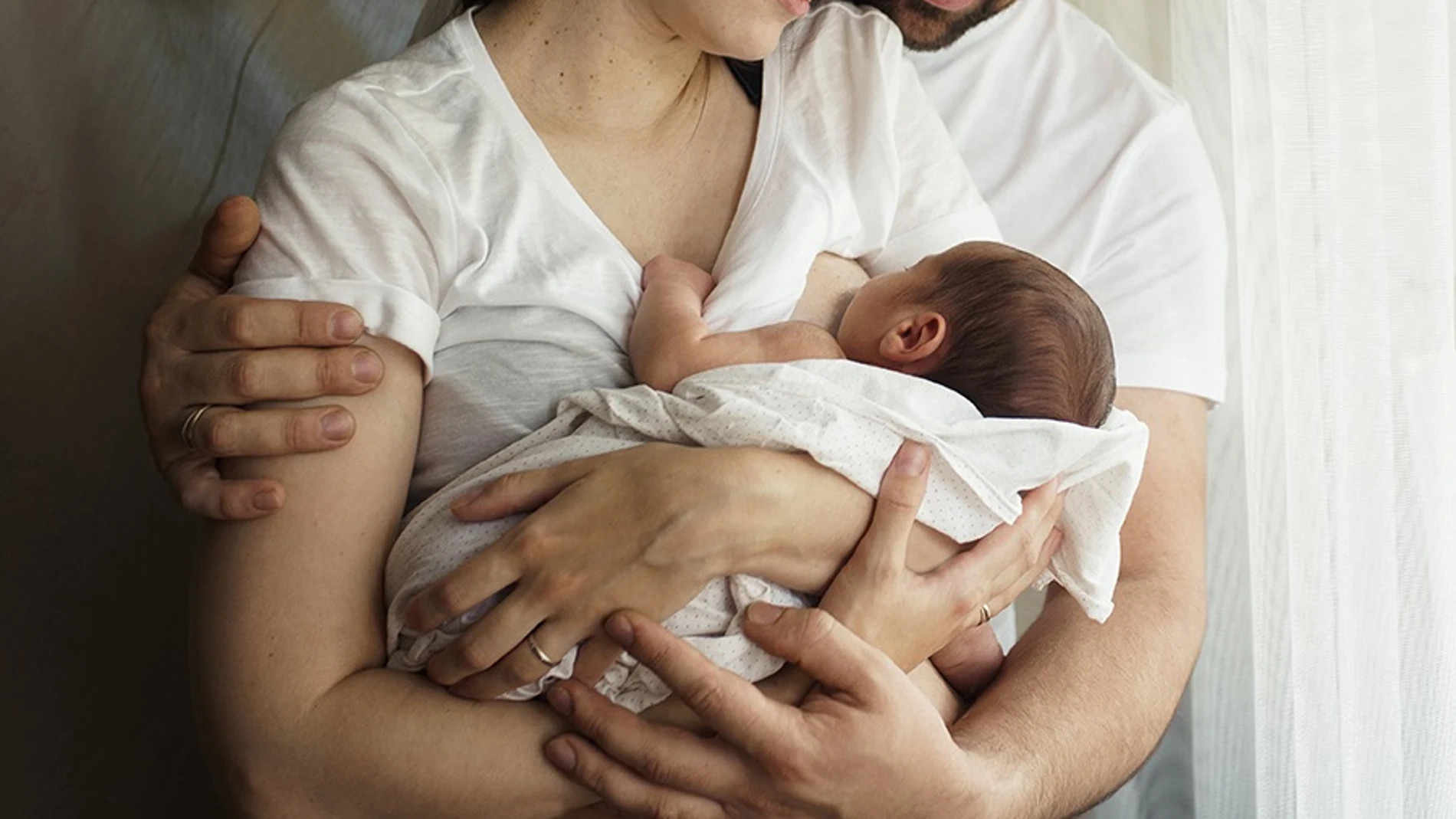 Una mujer da de mamar a su bebé