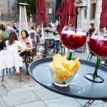 Un camarero llevando dos tintos de verano a una mesa de una terraza en Madrid