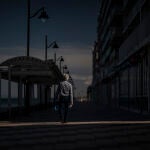 Un hombre pasea solitario por el paseo marítimo de Valencia sin llevar puesta la mascarilla