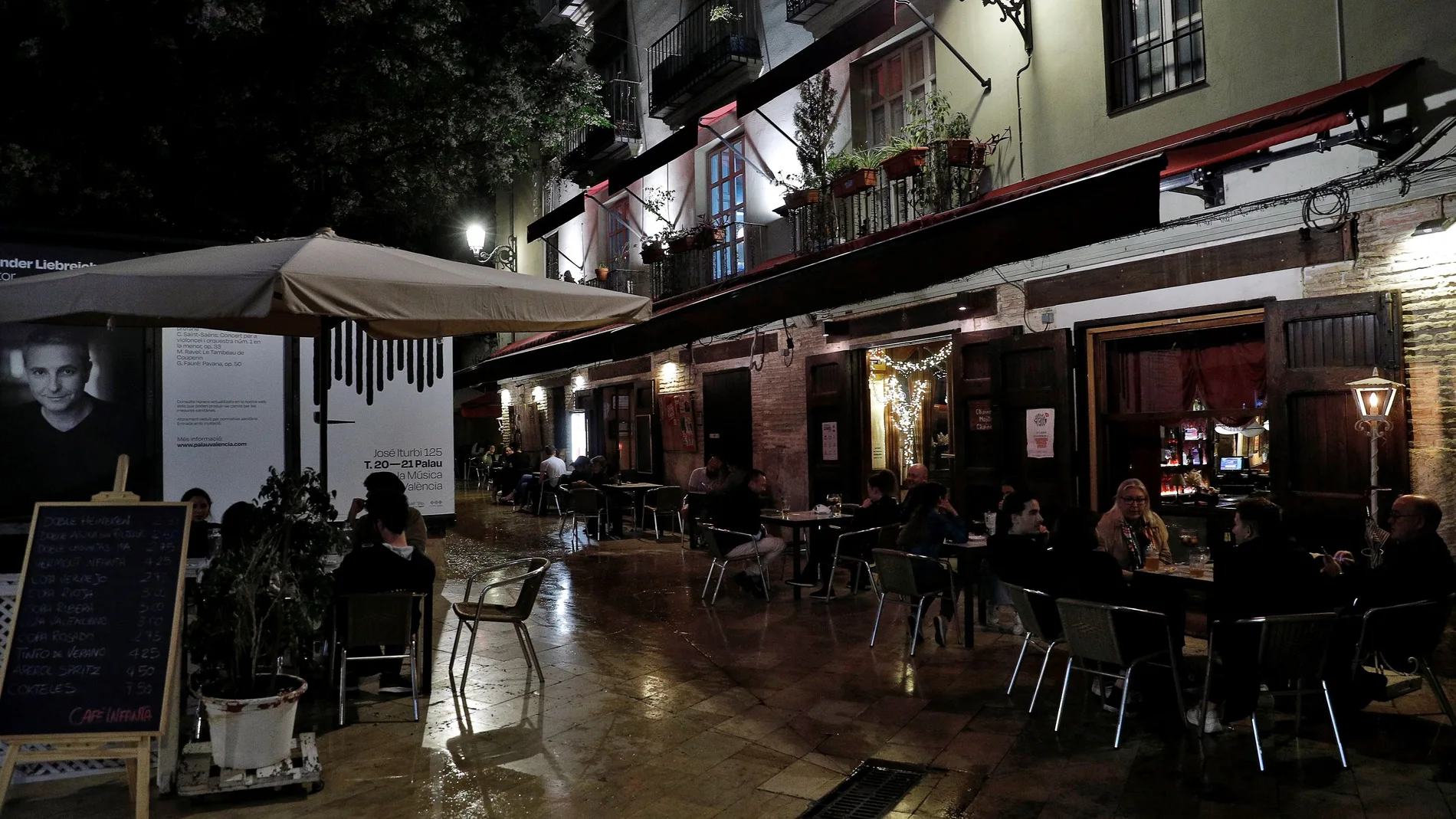 Varias personas disfrutan de la terraza de un bar en Valencia poco antes de la media noche