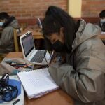 Students wearing masks to curb the spread of the new coronavirus take online classes with computers loaned to them by the teachers of the Gualberto Villarroel school in La Paz, Bolivia, Wednesday, May 12, 2021. The school's teachers and some parents are providing the devices to students who do not have access to the internet or a computer, or a cell phone to attend classes online. The school itself provides the internet signal. (AP Photo/Juan Karita)