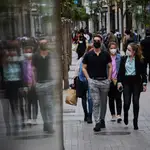 Gente pasea con mascarillas en la Gran Vía de Madrid.
