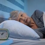 Mujer mayor preocupada en la cama por la noche que sufre de insomnio