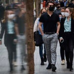 Gente pasea con mascarillas en la Gran Vía de Madrid.