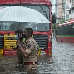 17 May 2021, India, Mumbai: A policeman helps a public transport driver to cross a flooded street due to heavy rain caused by cyclone 'Tauktae' in Mumbai. Photo: Ashish Vaishnav/SOPA Images via ZUMA Wire/dpaAshish Vaishnav/SOPA Images via / DPA17/05/2021 ONLY FOR USE IN SPAIN