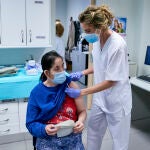 Una sanitaria vacuna a una mujer sin hogar en el Centro de Acogida Municipal Para Personas Sin Hogar San Isidro, a 20 de mayo de 2021