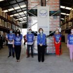La reina Sofía (c) posa con un grupo de voluntarios durante su visita este jueves al Banco de Alimentos de Valencia, ubicado en la localidad de La Pobla de Vallbona.