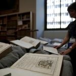 Una operaria despliega alguno de los 477 ejemplares devueltos por la Abadía del Valle de los Caídos a la Biblioteca Nacional este jueves. EFE/Juan Carlos Hidalgo
