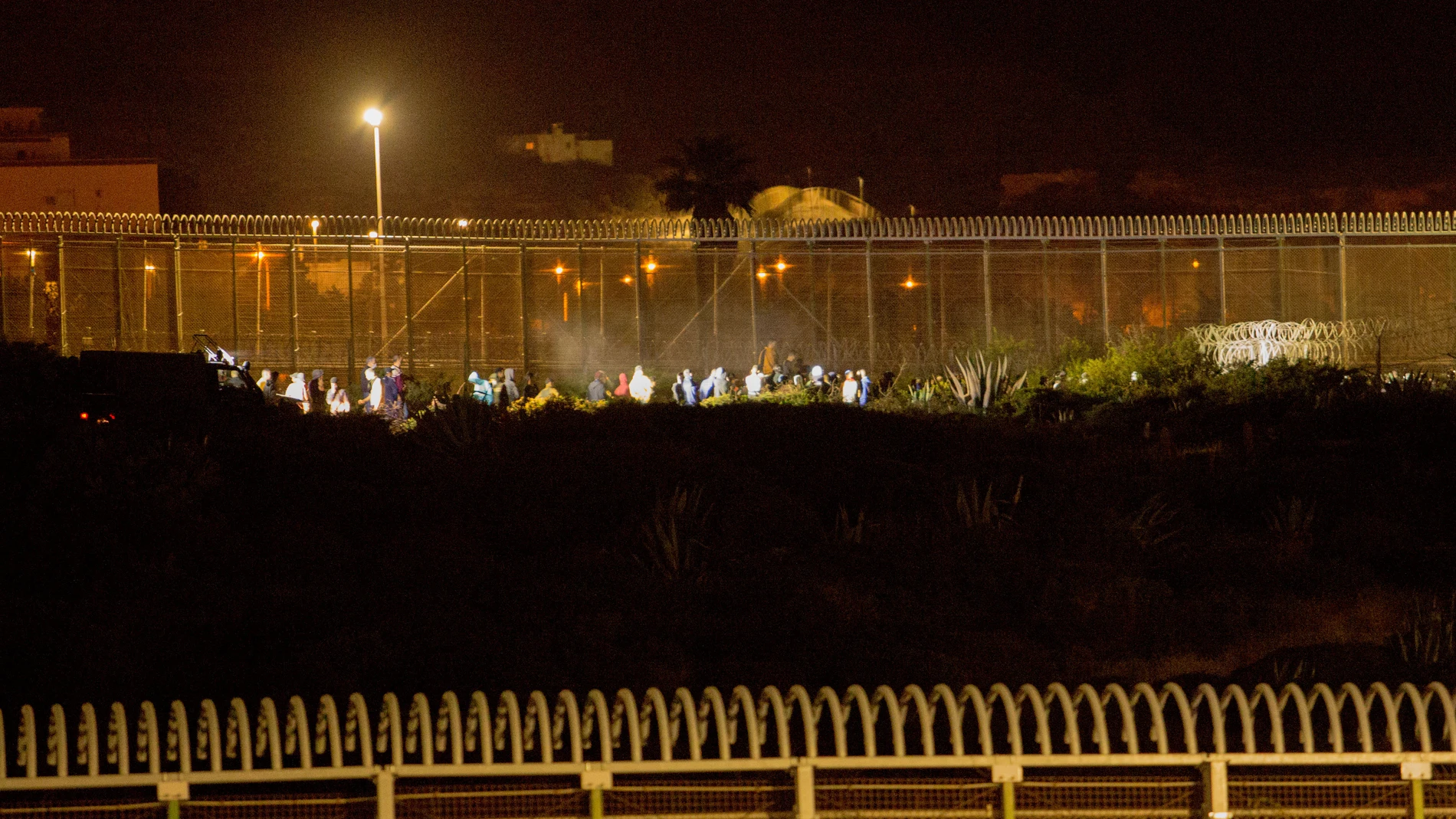 Varios marroquíes intentan llegar a suelo español desde la frontera que separa Melilla y Marruecos, a 21 de mayo de 2021, en Marruecos. La noche de este viernes medio centenar de personas ha intentado llegar a suelo español pero las fuerzas y cuerpos de seguridad desplegadas en la zona se lo han impedido. Este es uno de los muchos intentos de llegar a suelo español que se llevan produciendo desde el inicio de esta semana en la frontera que separa Marruecos de Ceuta y Melilla.21 MAYO 2021;MELILLA;SALTO;INMIGRACIÓN;MARRUECOS;FRONTERAÁngela Ríos / Europa Press21/05/2021