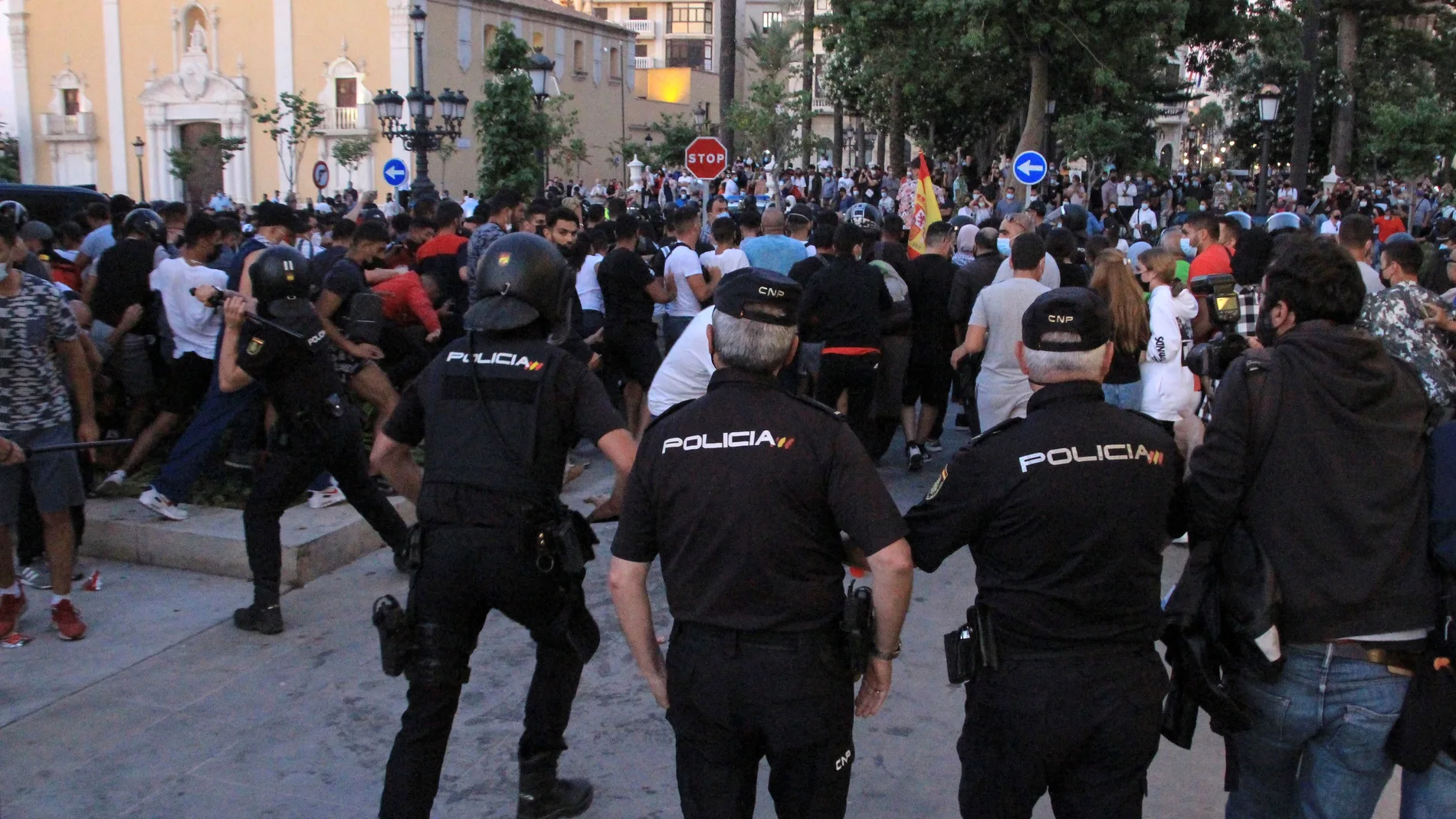 Miembros de la Policía Nacional se despliegan ante las protestas hoy lunes en la Plaza de los Reyes de Ceuta, tras la prohibición del acto previsto por el presidente de Vox, Santiago Abascal, en la ciudad autónoma. EFE / Reduan.