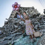 Una niña coge unos globos en medios de los escombros provocados durante los once días de ofensiva militar en Gaza