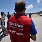 Un trabajador de Cáritas Diocesana reparte alimentos a migrantes