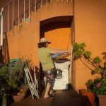 Una mujer ante una lavadora en una terraza
